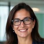 Retrato profissional de Ana Paula Rodrigues, especialista em finanças públicas, sorrindo e com óculos, transmitindo confiança e inteligência.
